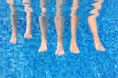 Funny underwater family legs in swimming pool, under water view
